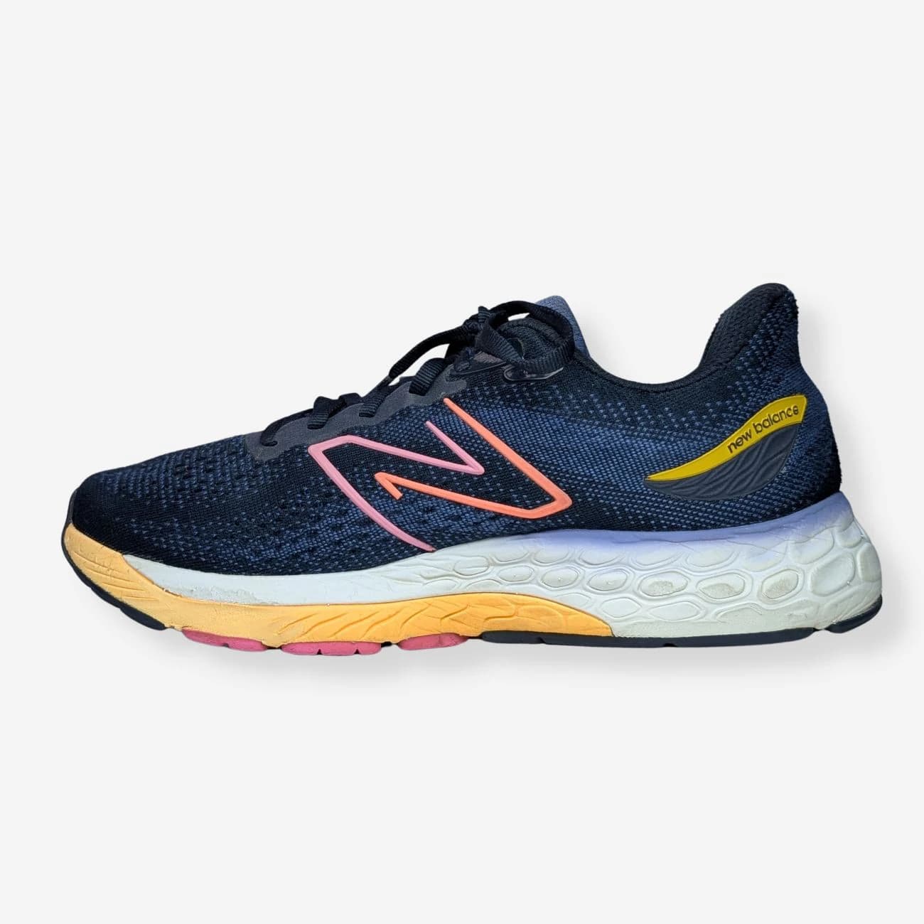 New Balance Women's Fresh Foam X 880v12 running shoes in navy blue with pink and yellow accents. Features a breathable mesh upper, cushioned Fresh Foam midsole, and durable rubber outsole. Ideal for running and casual wear.