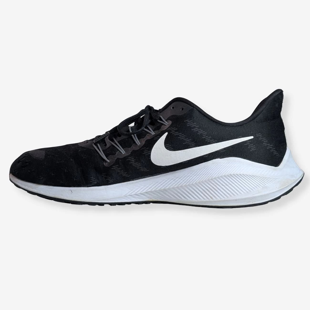 Nike Air Zoom Vomero 14 running shoes in black and white, featuring a breathable mesh upper, cushioned sole, and sleek design. Ideal for runners seeking comfort and style. Size and model details not visible.