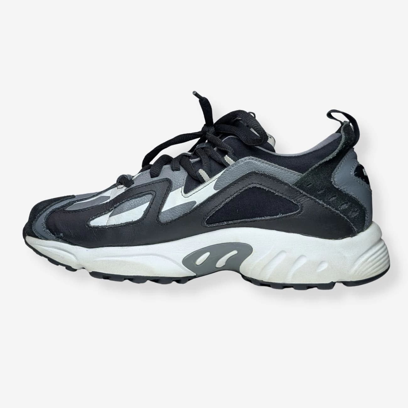 Reebok DMX Series 1200 LT sneakers featuring a sleek black and grey design with a textured upper, cushioned sole, and lace-up closure. Ideal for casual wear and athletic activities.